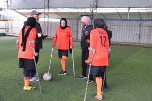 DEIR AL-BALAH: La fotoreporter Kifah Al-Fakhouri ascolta il suo allenatore, mentre combatte le amputazioni a catena grazie al calcio. Foto: Nelly Al-Masri